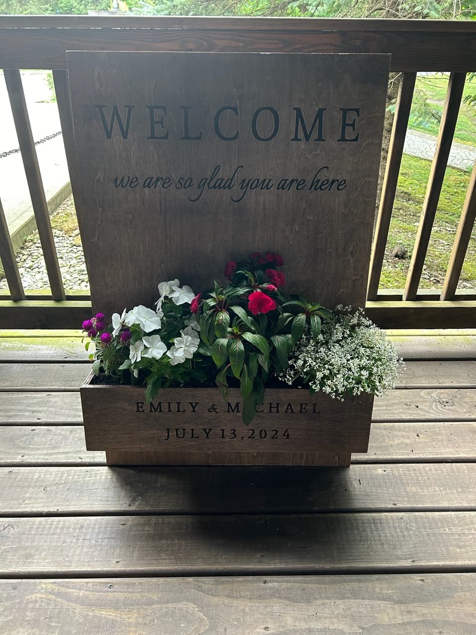 Custom wood wedding welcome sign displayed with floral planter