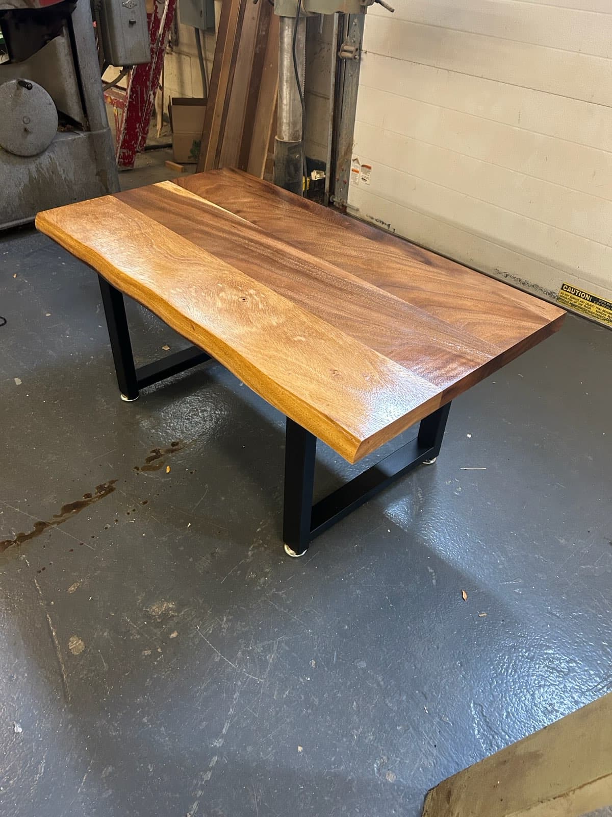 Walnut slab desk with black metal trapezoid legs in a home office